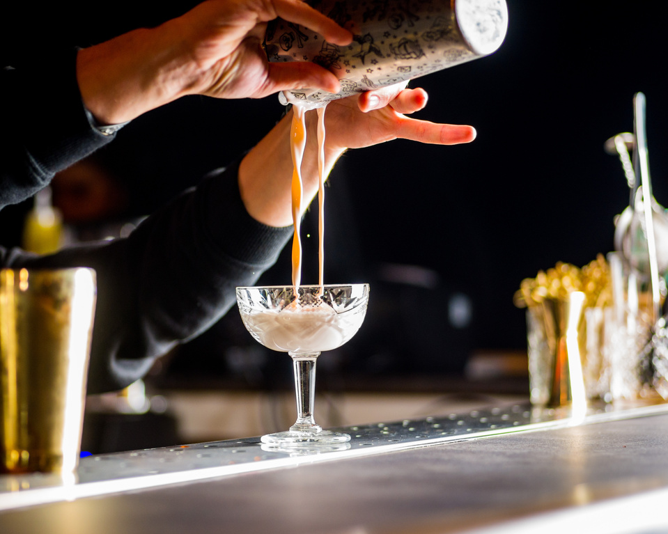 bartender is preparing a cocktail. Bartender pours a cocktail